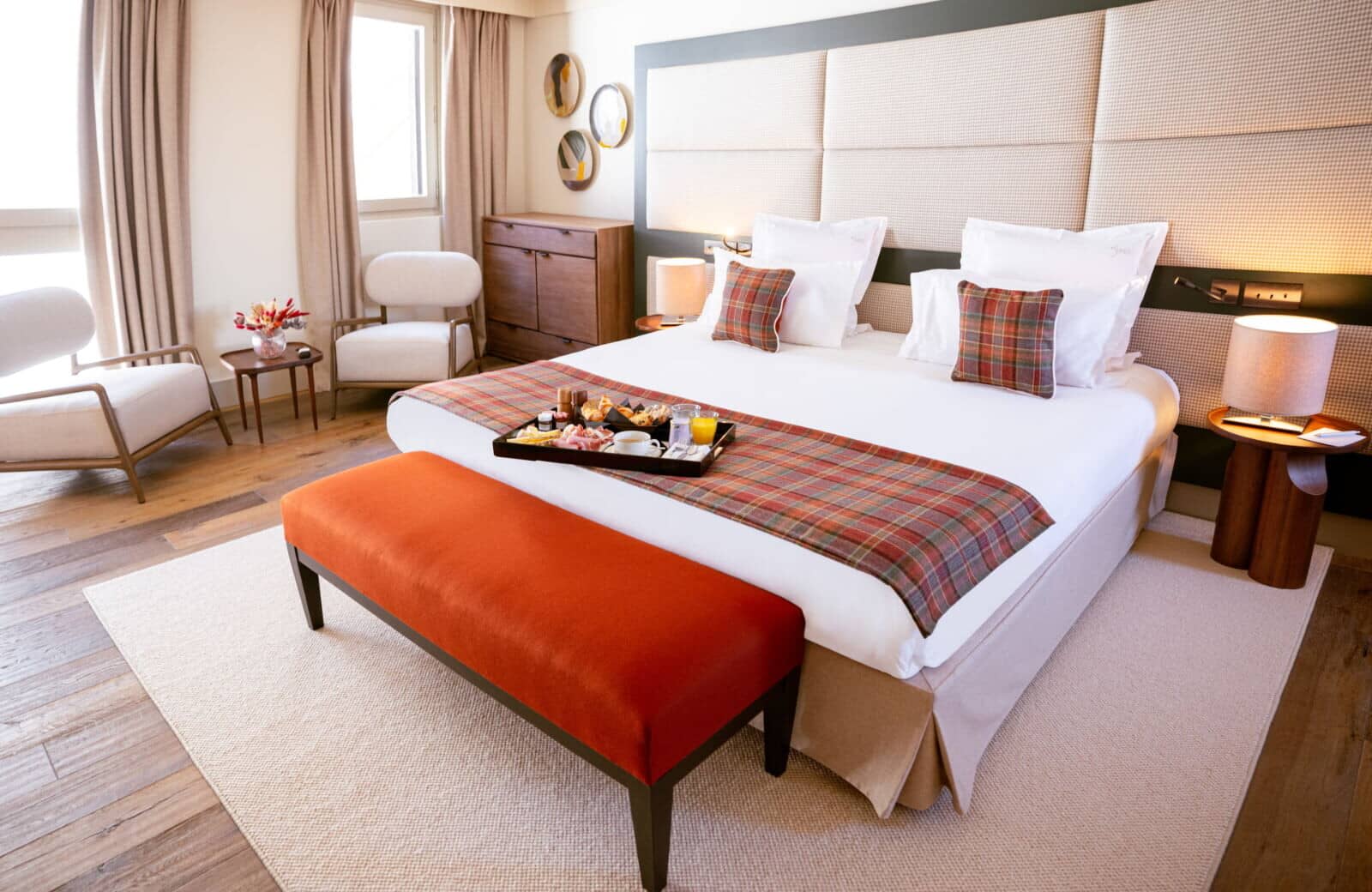 Primary bedroom with king bed, upholstered headboard, and seating area