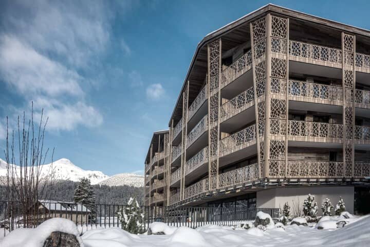 Multi-story exterior featuring private balconies with decorative wood screens