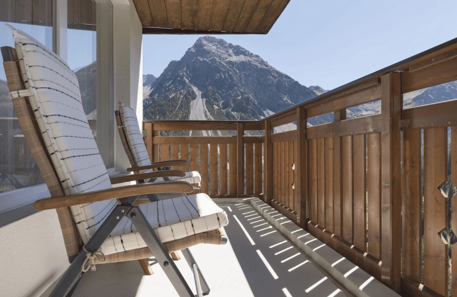 Private balcony with lounge seating for two and mountain views