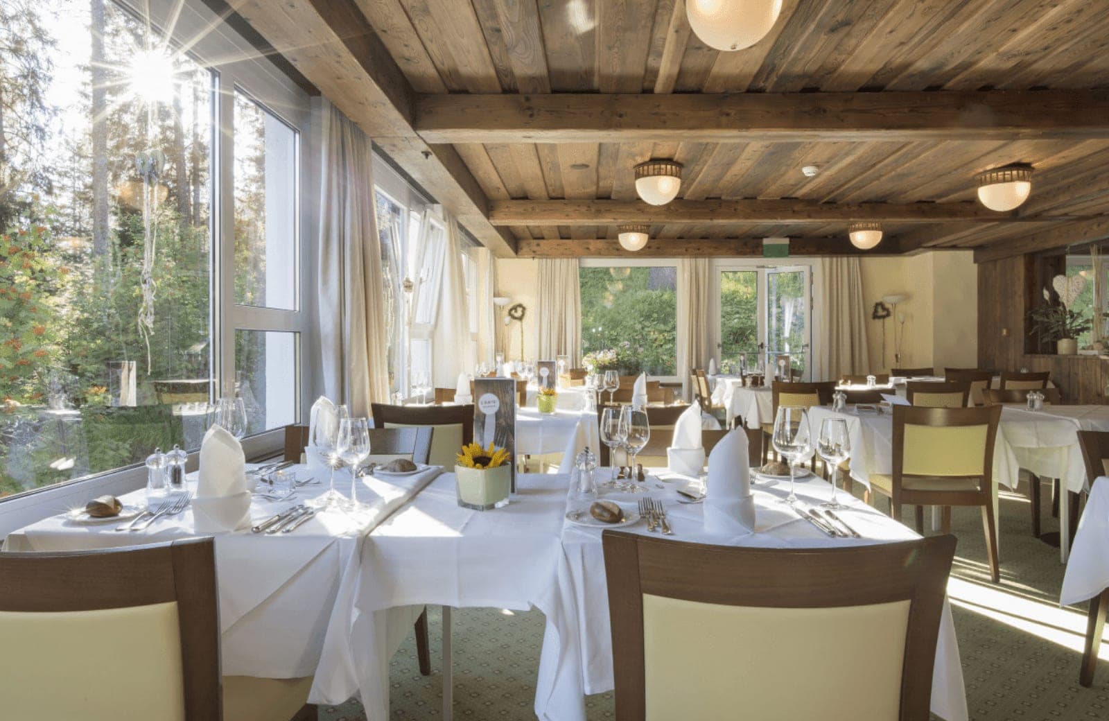 Dining area with timber-beamed ceiling and forest views