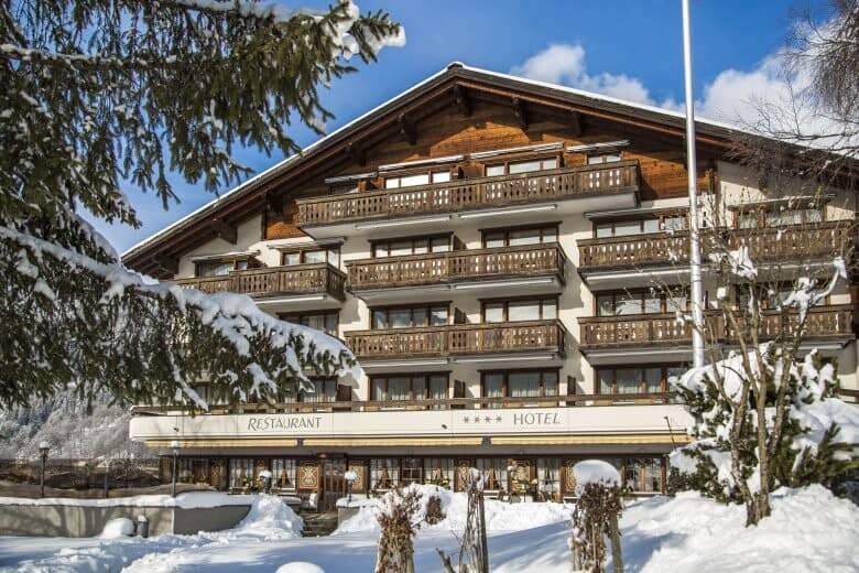Chalet-style exterior featuring private wooden balconies and on-site restaurant