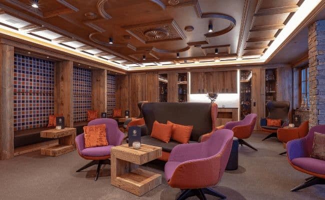 Lounge area with coffered wood ceiling and velvet armchair seating