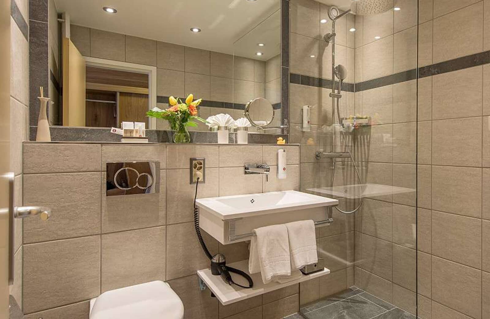 Bathroom with walk-in rainfall shower and wall-mounted hair dryer