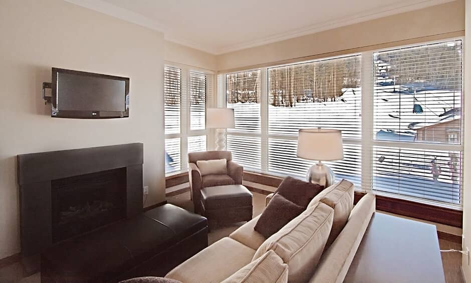 Living area with gas fireplace and floor-to-ceiling ski slope views