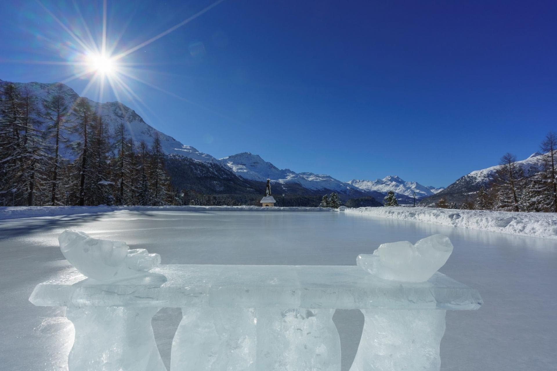 Private ice rink with sculpted ice bench and mountain views