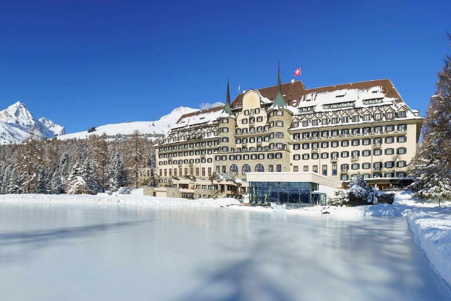 Ski-in/ski-out hotel exterior with direct access to frozen lake ice rink