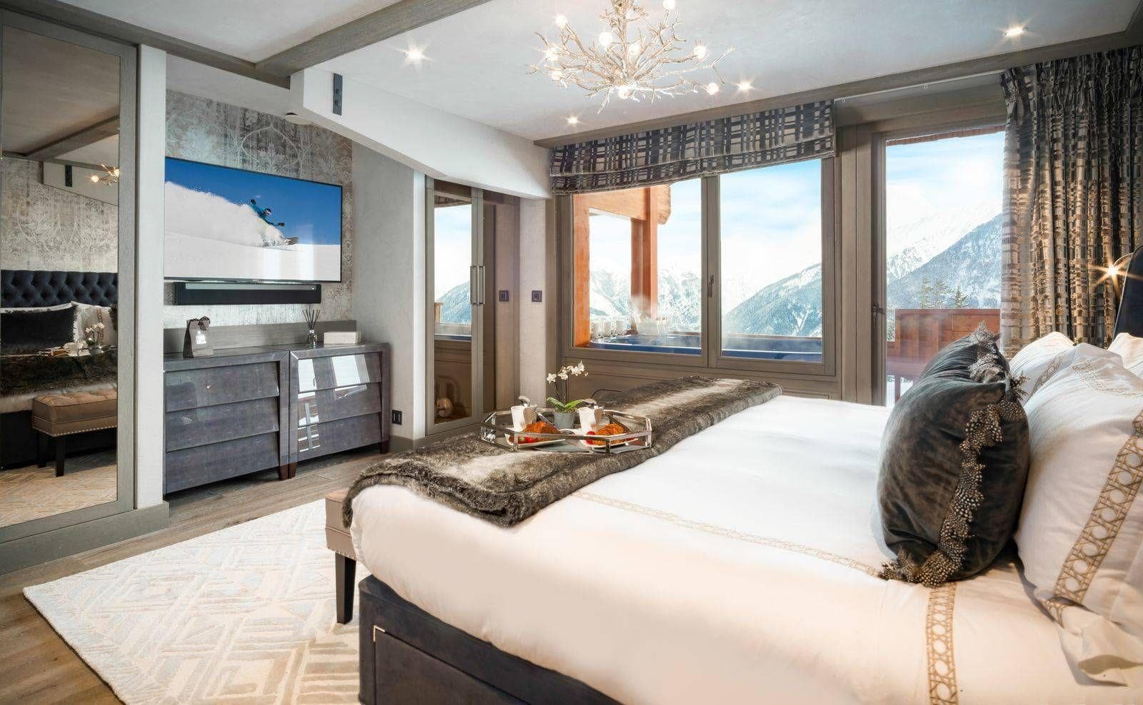 Primary bedroom with mountain views and private balcony hot tub