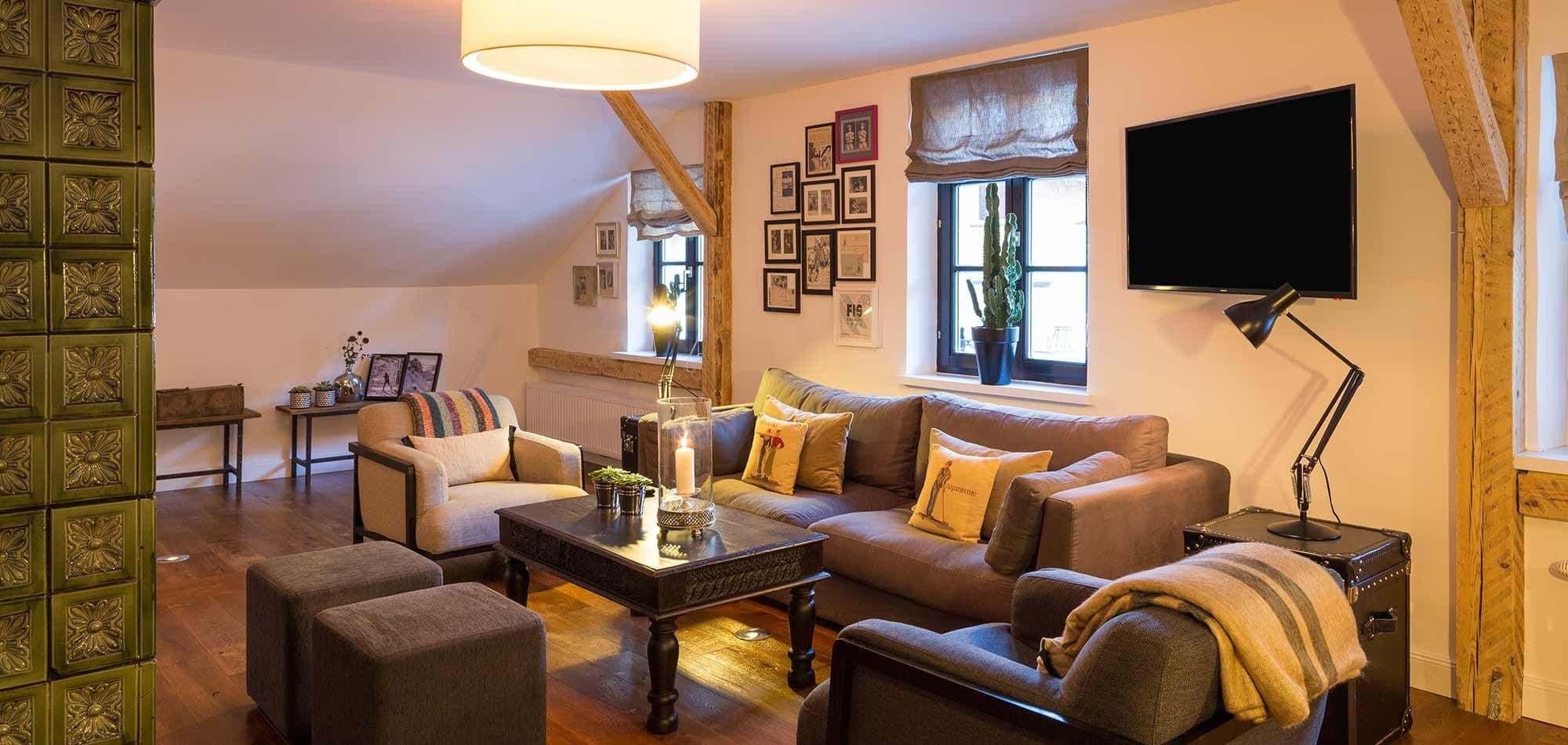 Living area with smart TV and traditional green tile masonry heater
