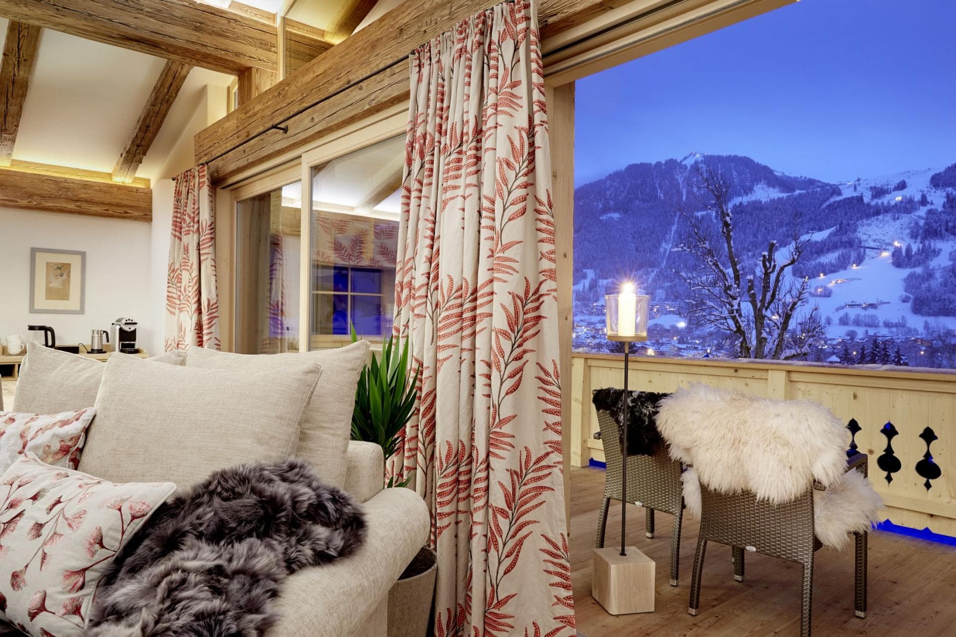 Living area with private balcony overlooking illuminated ski slopes