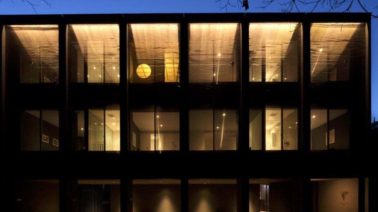 Exterior facade with floor-to-ceiling windows and mesh privacy screens