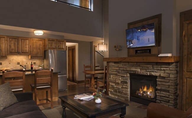 Open living area with stone fireplace and breakfast bar seating