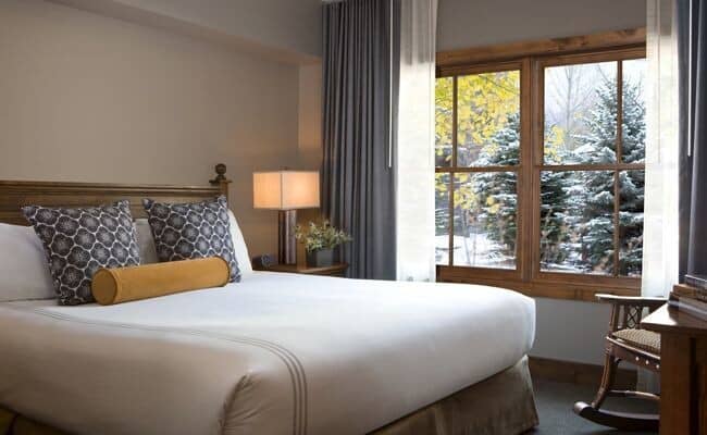 Guest bedroom with king bed and snow-covered forest views