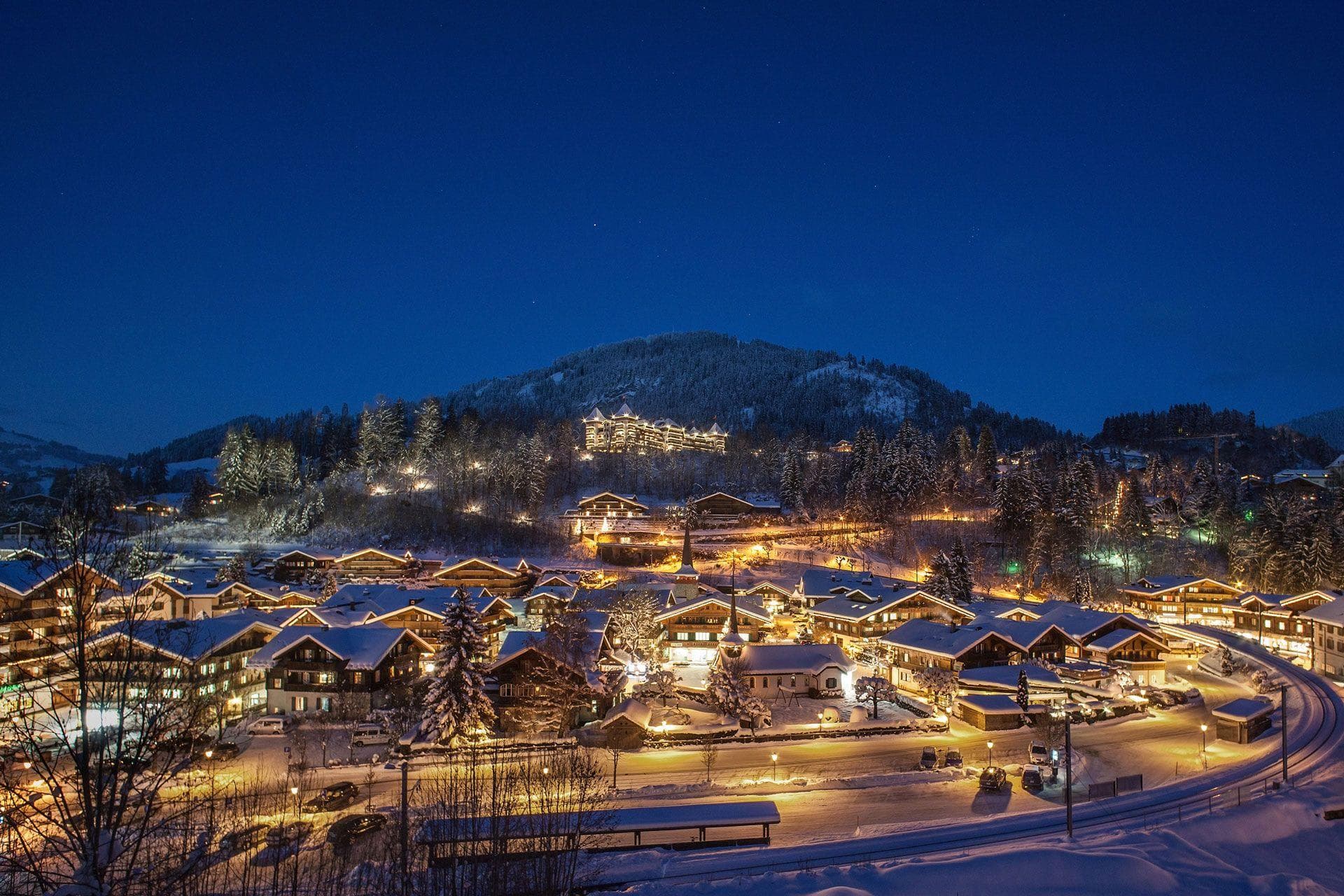 Aerial village view at night with Gstaad Palace in the background