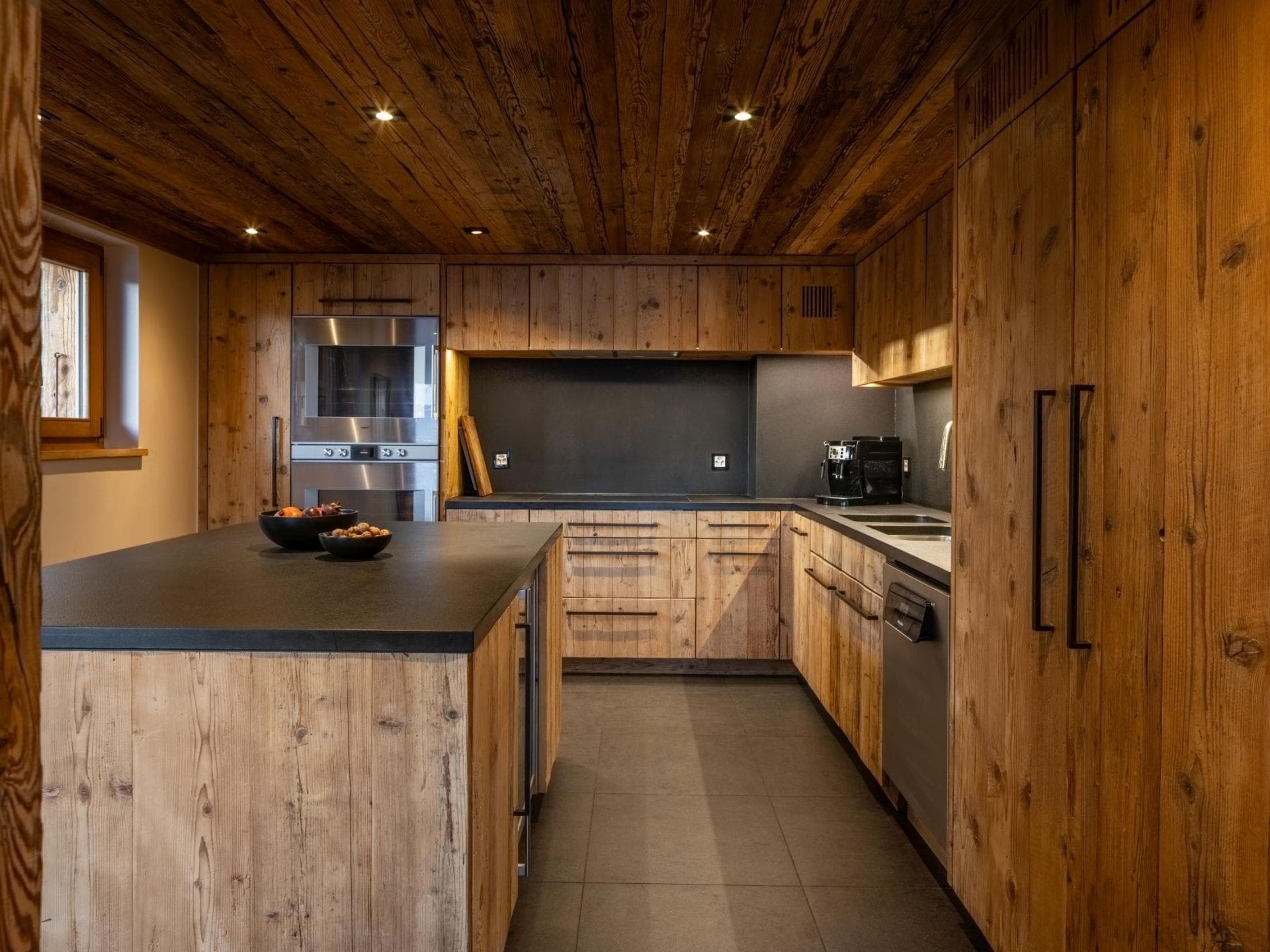 Kitchen with reclaimed wood cabinetry, double wall oven, and wine fridge