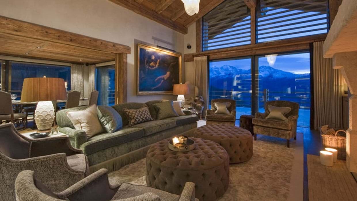 Living area with wood-beamed ceilings and floor-to-ceiling mountain views