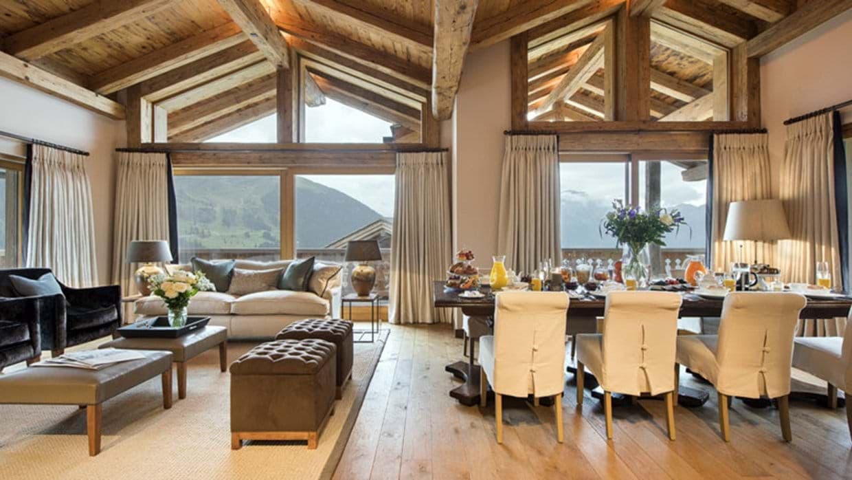 Open-plan living and dining area with vaulted timber ceilings and mountain views