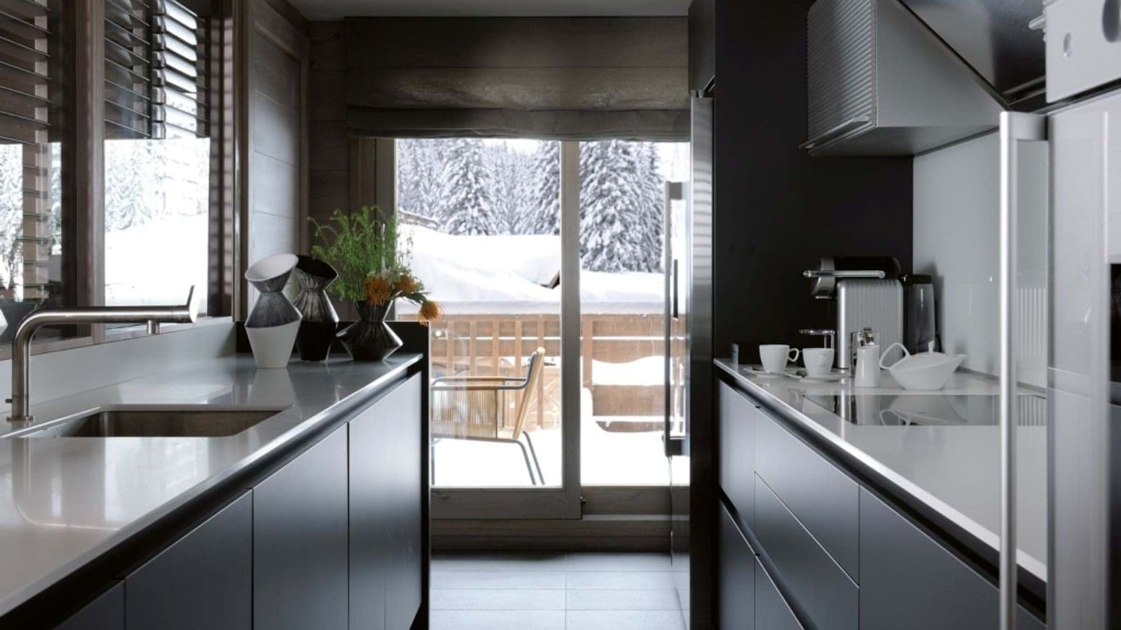 Galley kitchen with Nespresso machine and access to snowy balcony