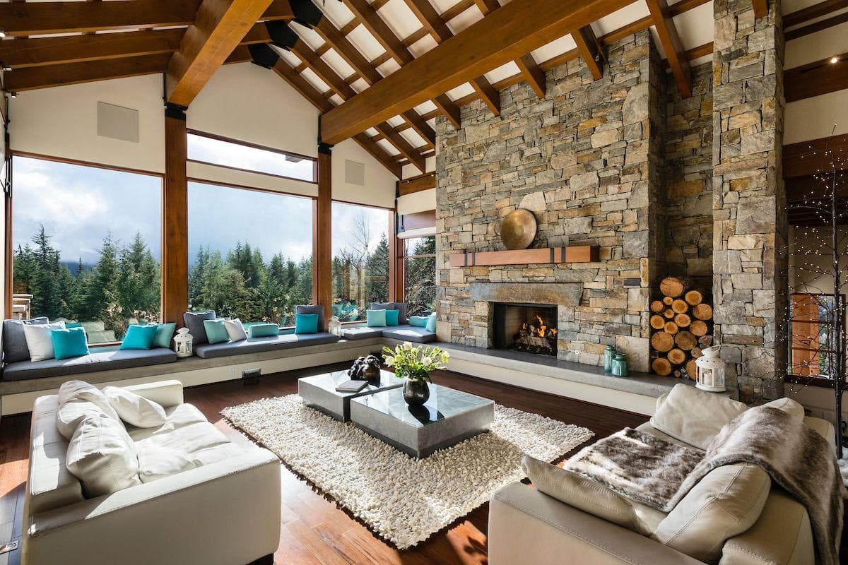 Living room with wood-burning stone fireplace and integrated window bench seating