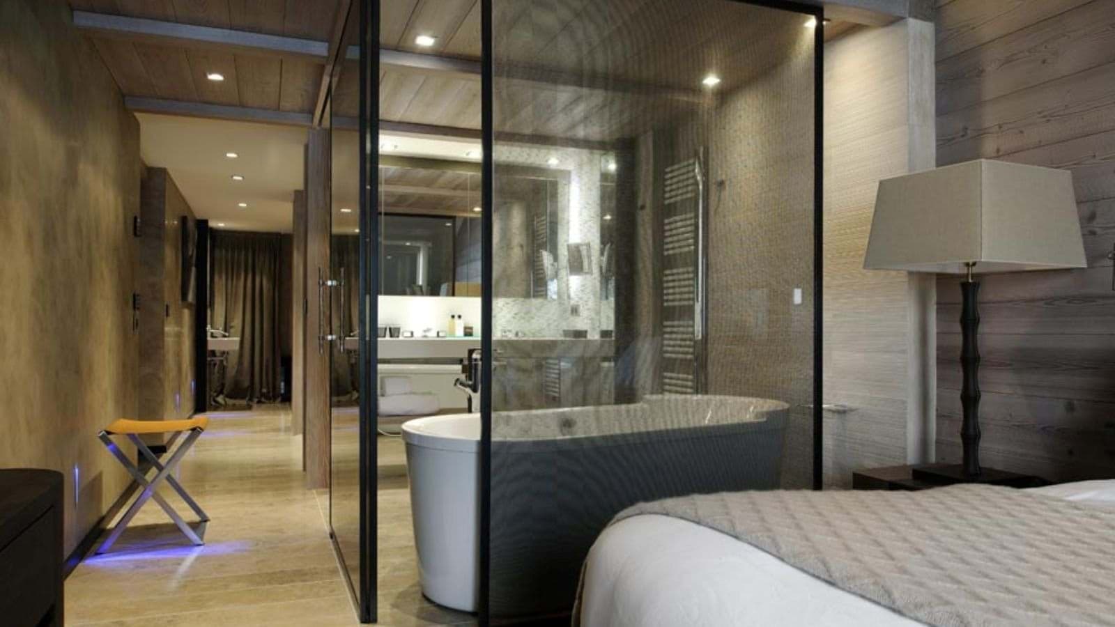 En suite bathroom with freestanding soaking tub and glass partition
