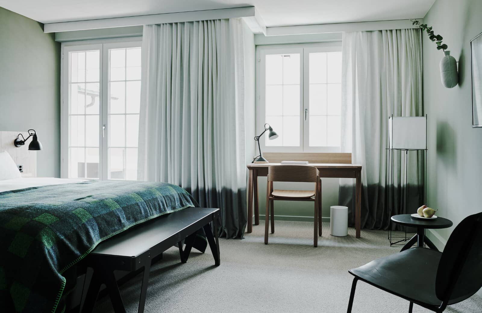 Bedroom featuring dedicated workspace and floor-to-ceiling window treatments