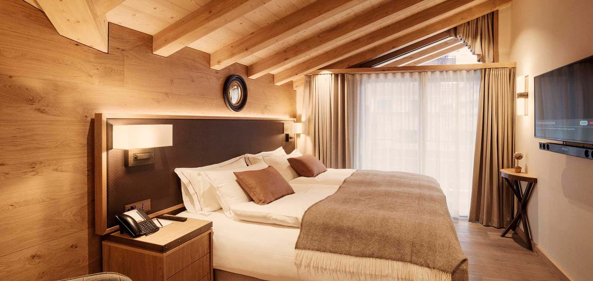 Bedroom with vaulted wood ceilings, king bed, and Smart TV
