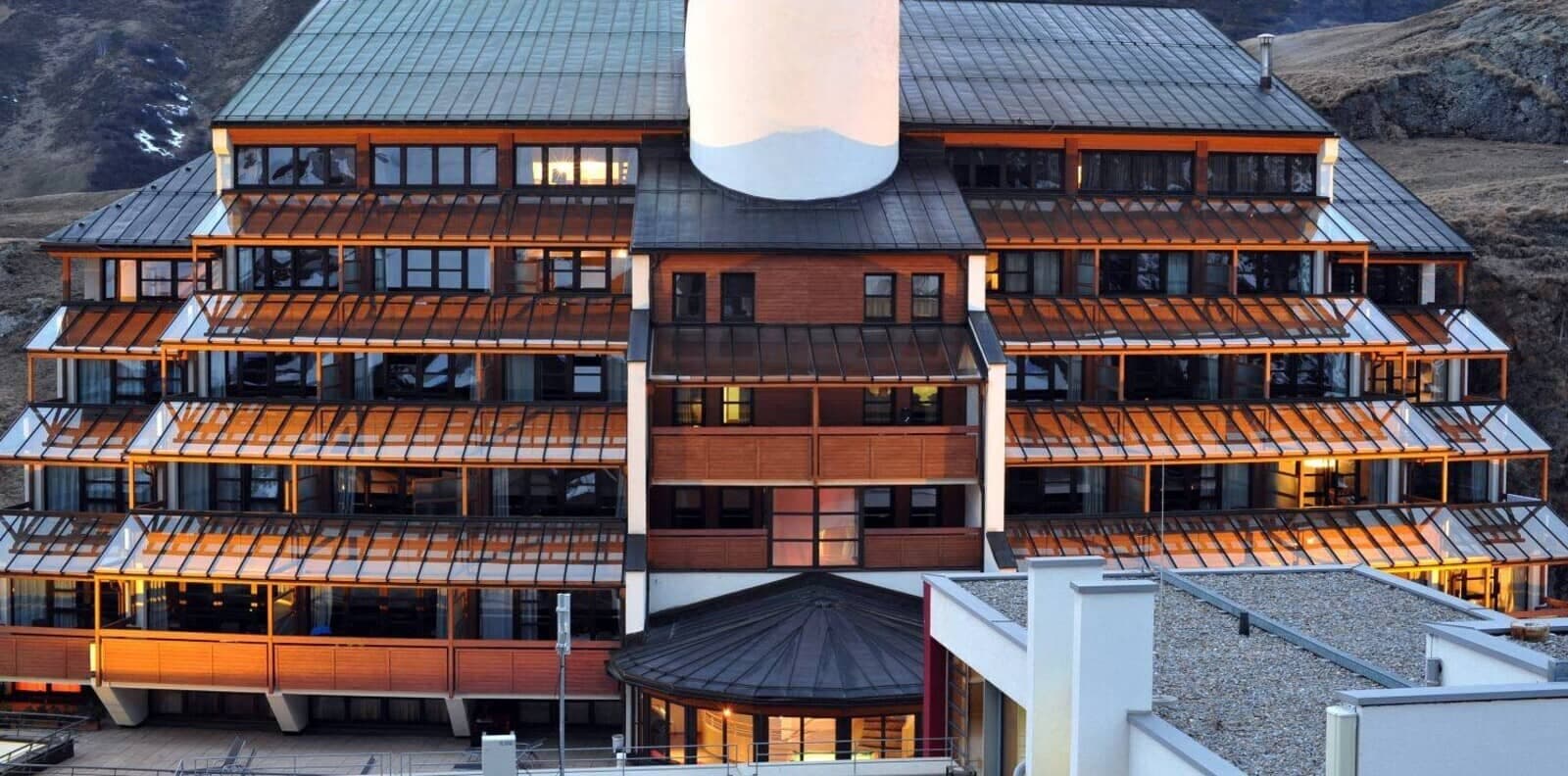 Exterior view showing tiered private balconies with glass awnings