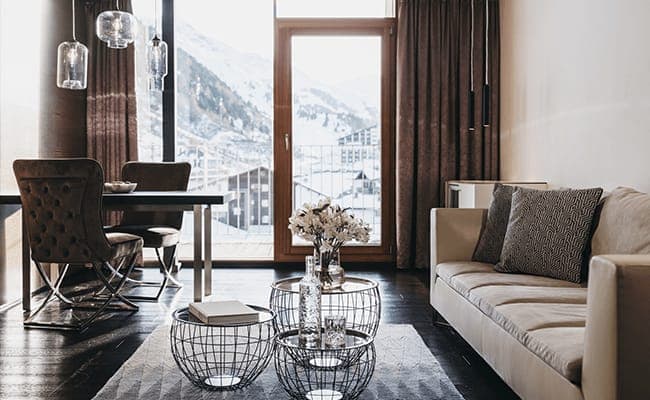 Open living area with mountain-view balcony and dining seating for two