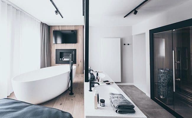 Primary bathroom with soaking tub, dual vanity, and private sauna