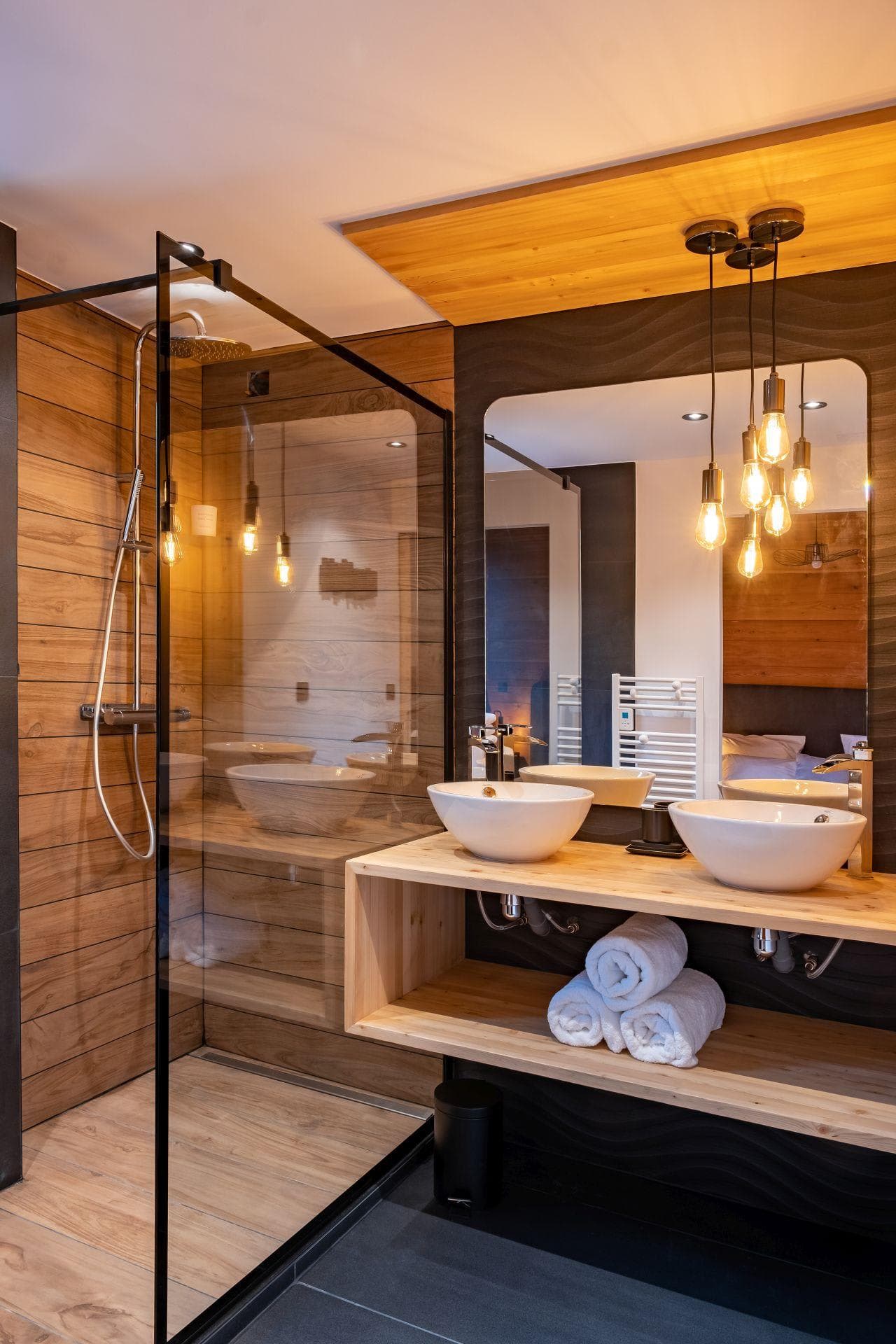 Bathroom with dual vessel sinks and glass-enclosed rainfall shower
