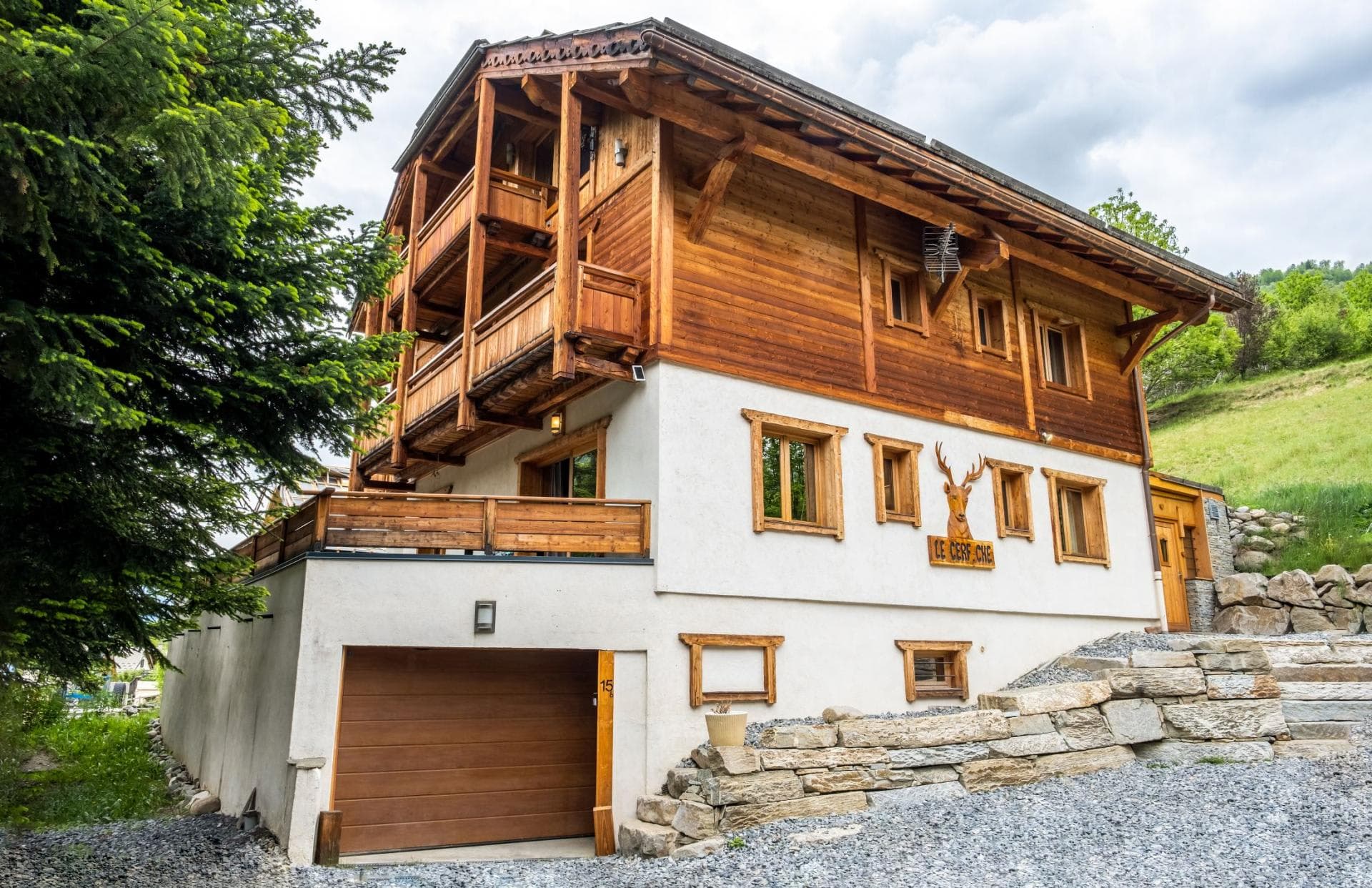 Chalet exterior featuring heated garage and multiple private balconies