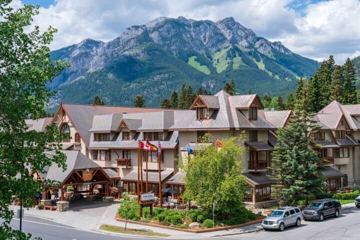 Hotel exterior with covered porte-cochère and mountain backdrop