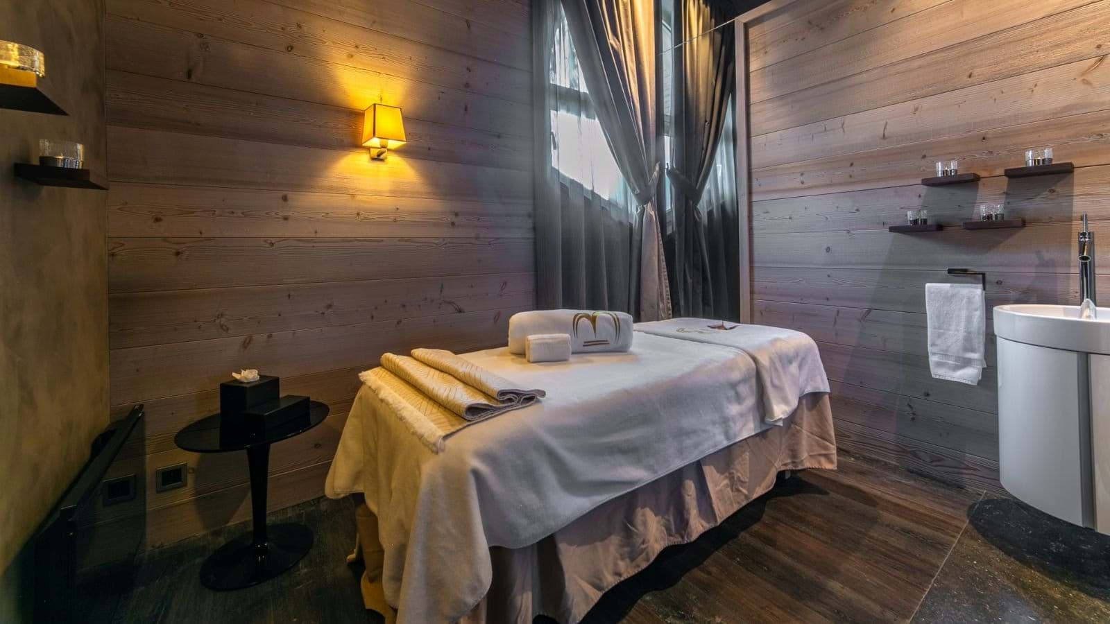 Private massage room with treatment table and in-room vanity