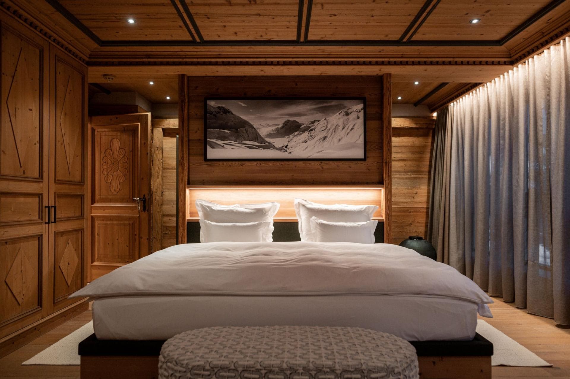 Primary bedroom with king bed, reclaimed wood paneling, and built-in wardrobes