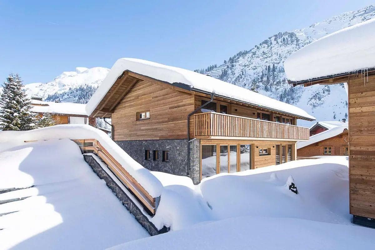 Chalet exterior with timber balcony and direct mountain views
