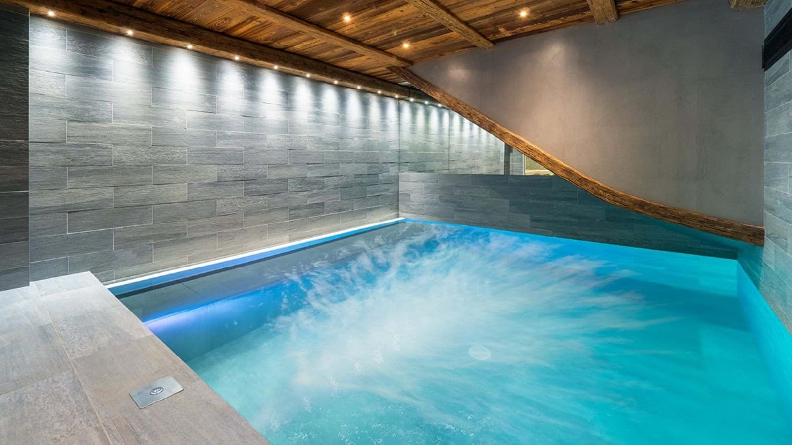Indoor pool with integrated massage jets and stone walls