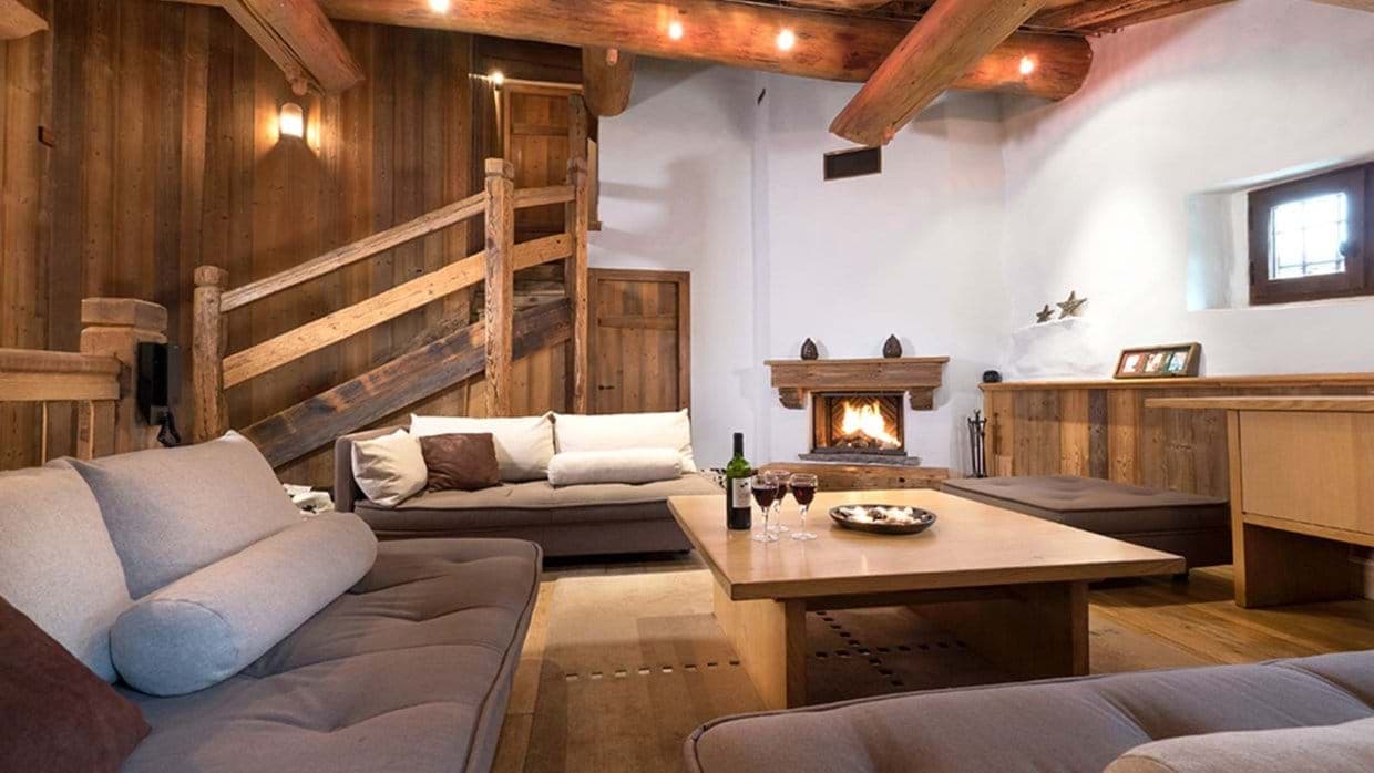 Living area with wood-burning fireplace and exposed timber beams