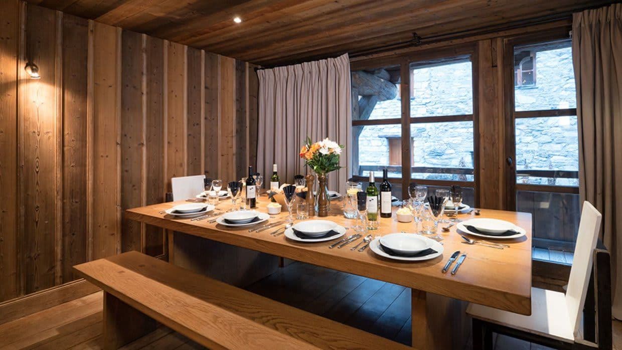 Dining area with bench seating for 8 and wood-paneled walls
