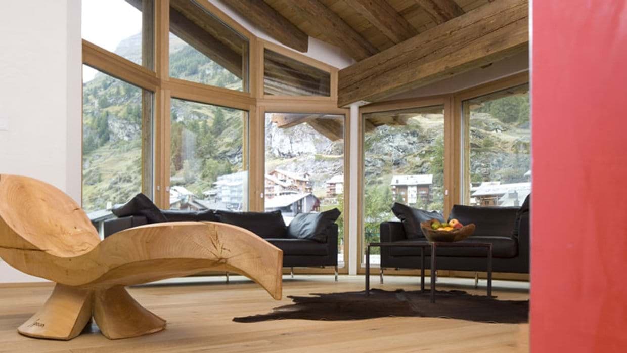 Living area with floor-to-ceiling windows and panoramic alpine village views