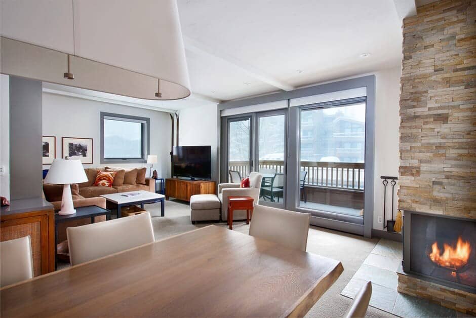 Open living area with wood-burning fireplace and private balcony access