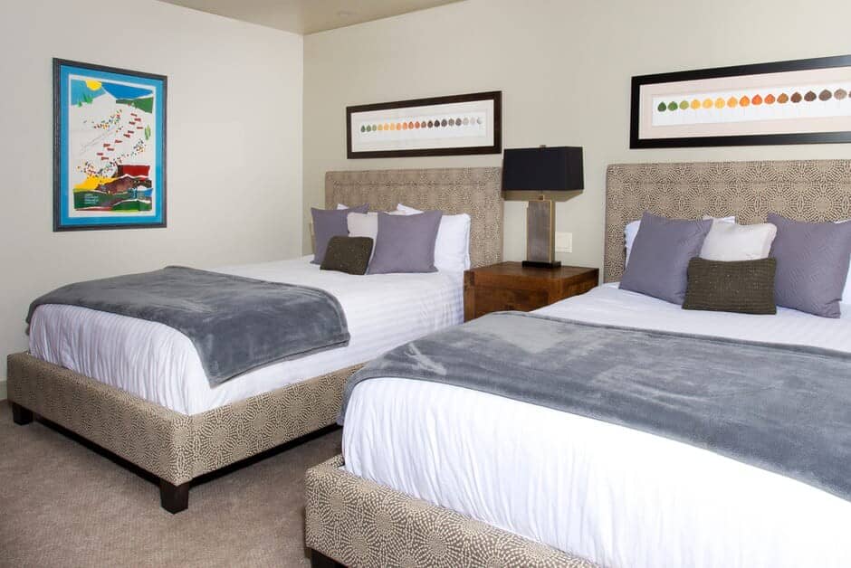 Guest bedroom with two queen beds and shared bedside lamp