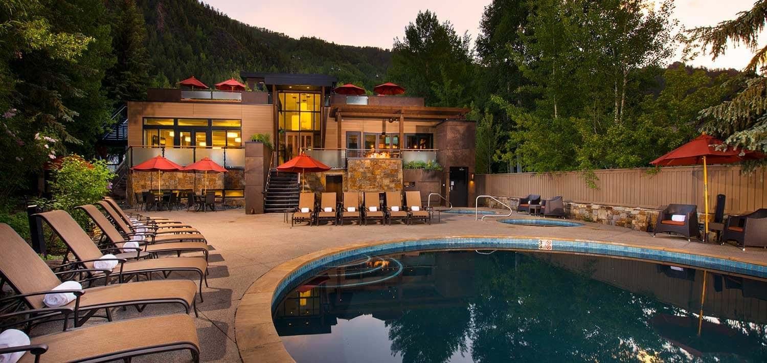 Outdoor pool and hot tub with lounge seating and mountain backdrop