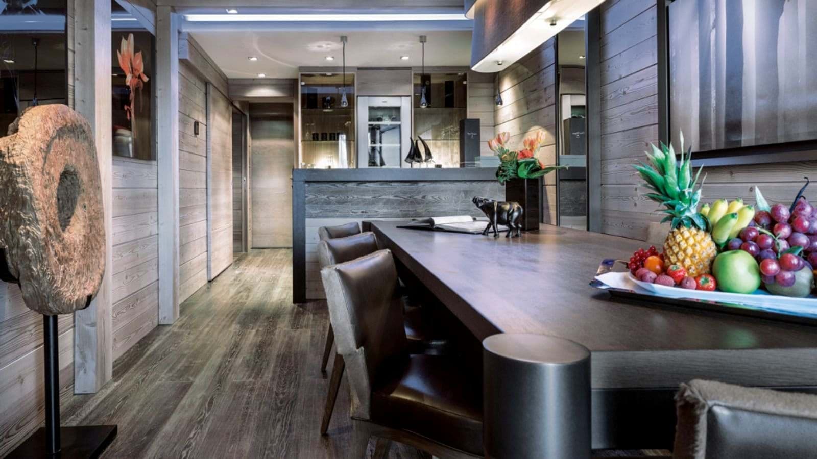 Dining area with wood paneling and bar featuring wine fridge