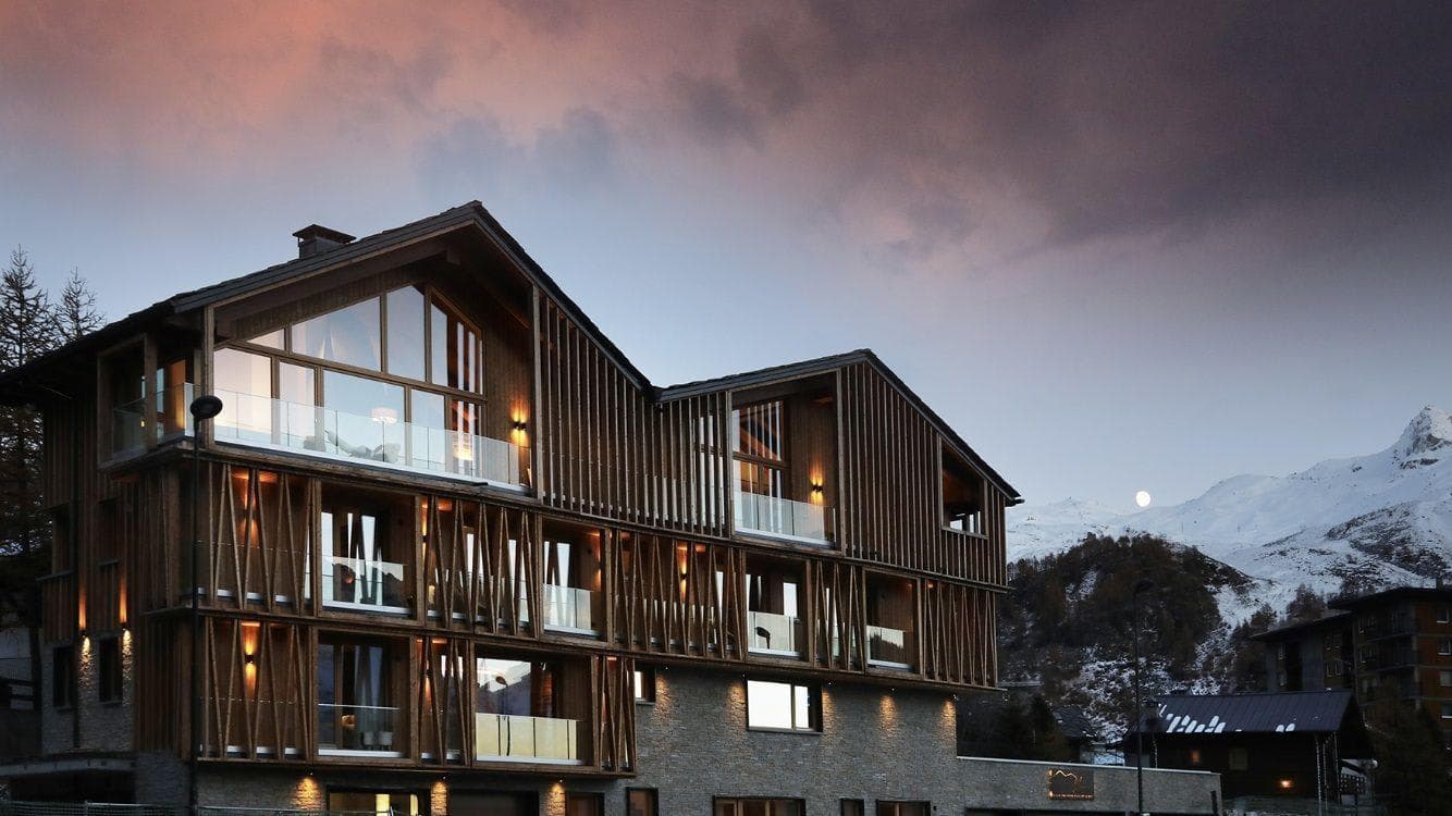 Chalet exterior featuring private glass balconies and mountain views
