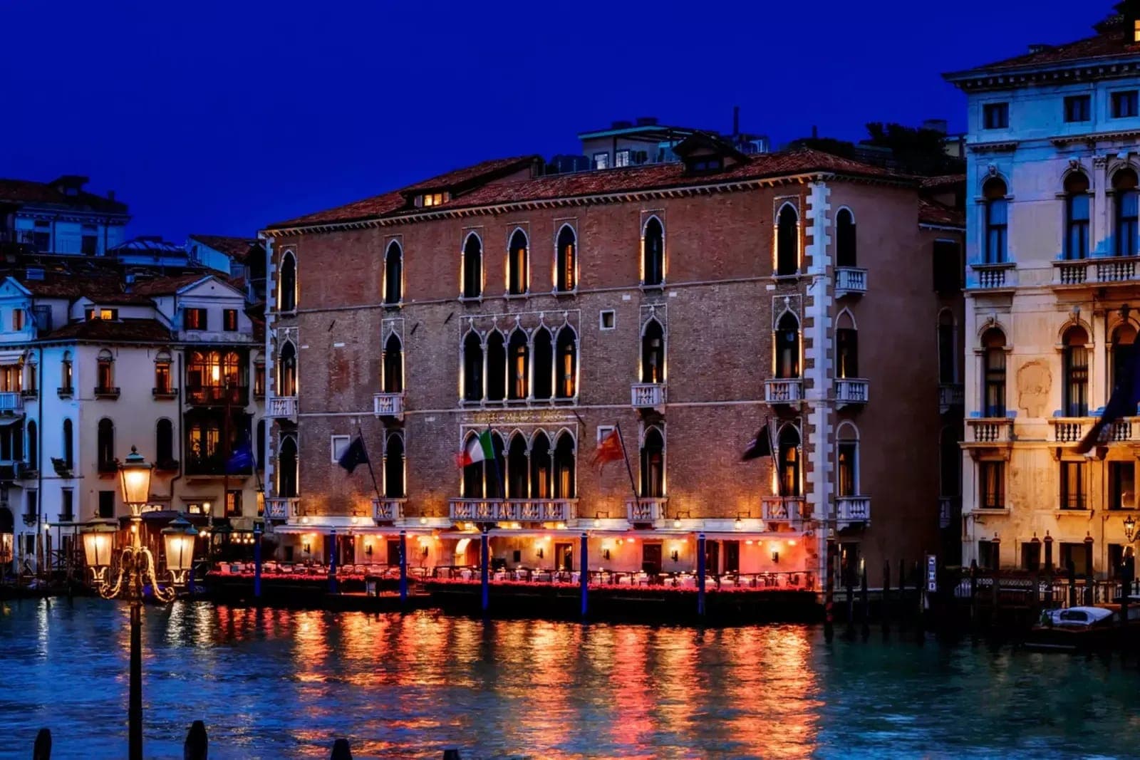 Venetian palazzo exterior with waterfront terrace dining and Grand Canal views