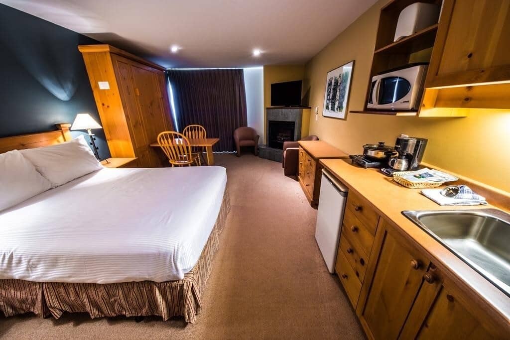 Studio suite with queen bed, kitchenette, and gas fireplace