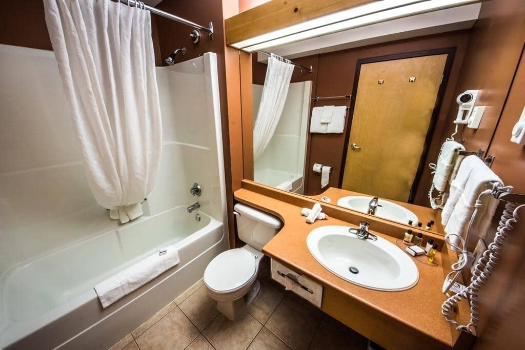 Bathroom with shower-tub combo and wall-mounted hair dryer