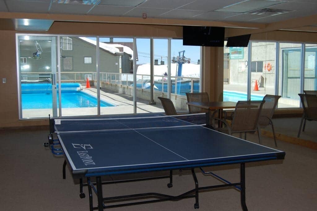 Indoor game room with ping pong table and poolside view