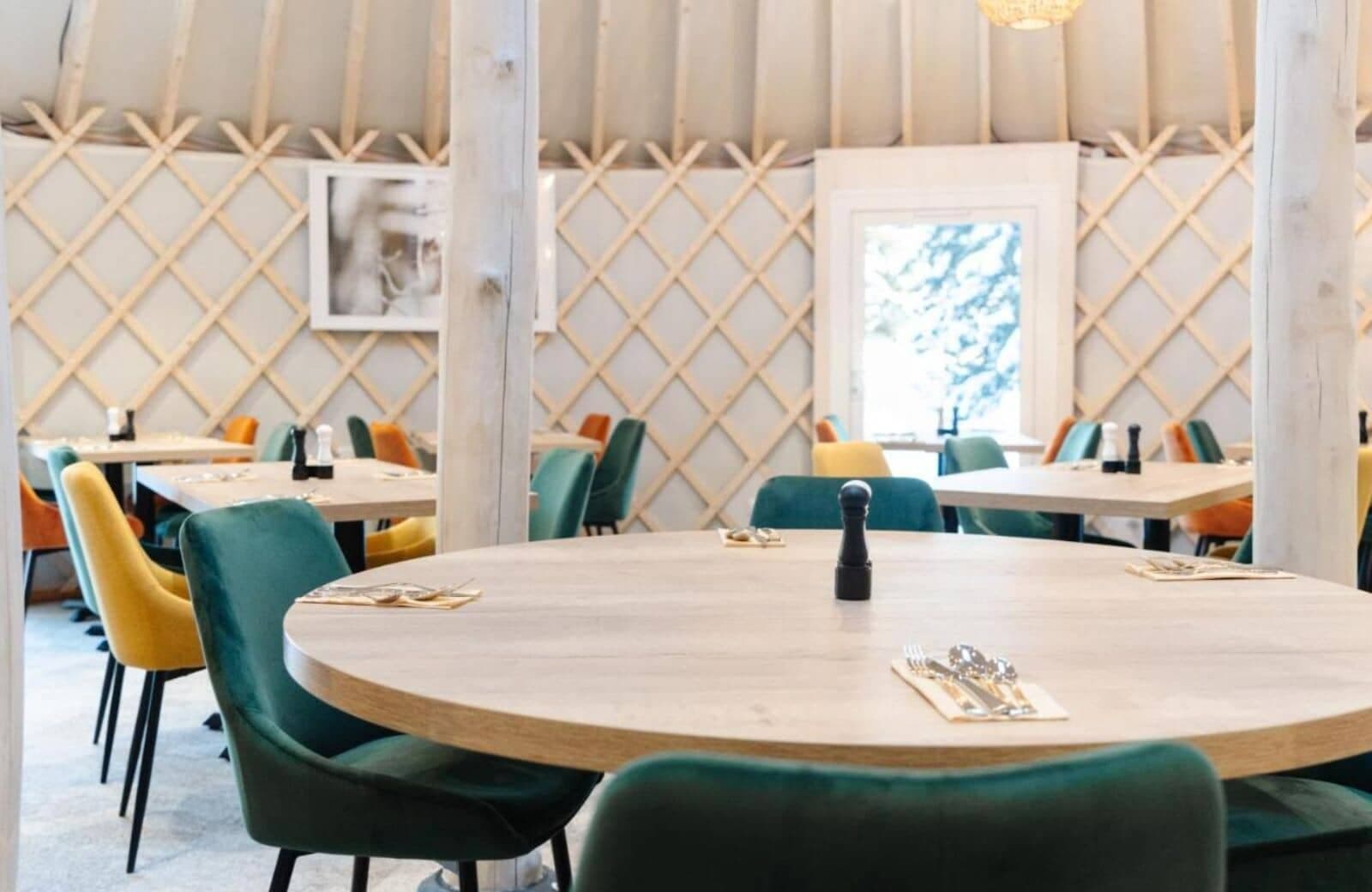 Yurt dining room with round and square tables for group seating