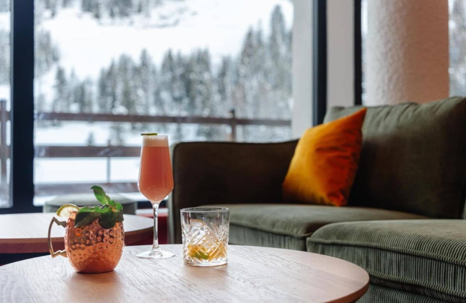 Lounge seating area with cocktail service and snow-covered forest views