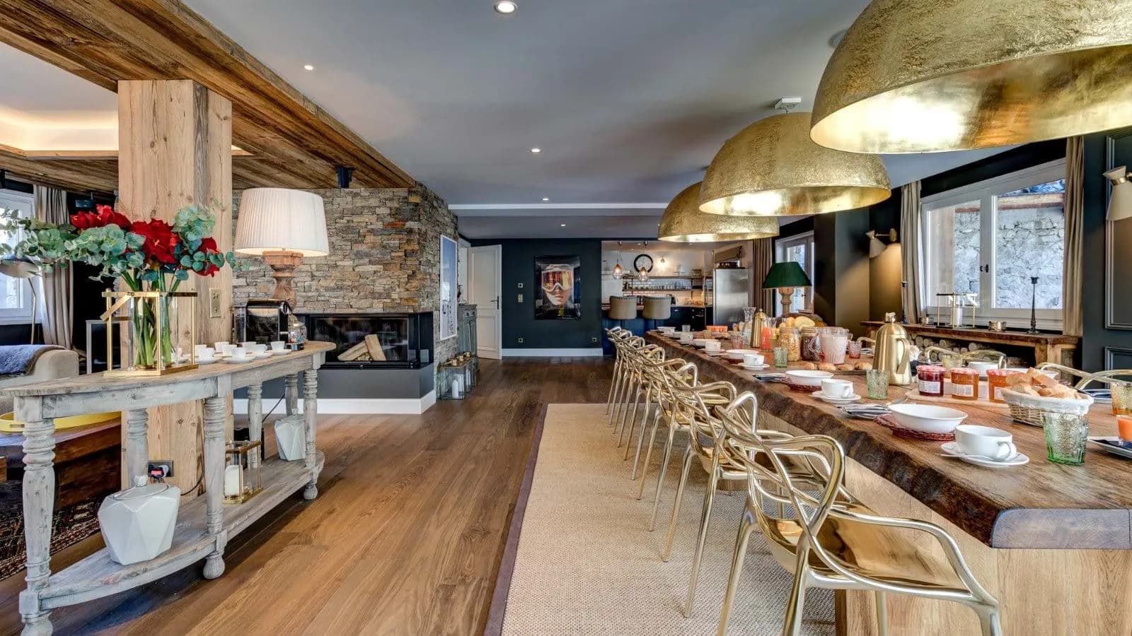 Live-edge dining table beside the stone fireplace